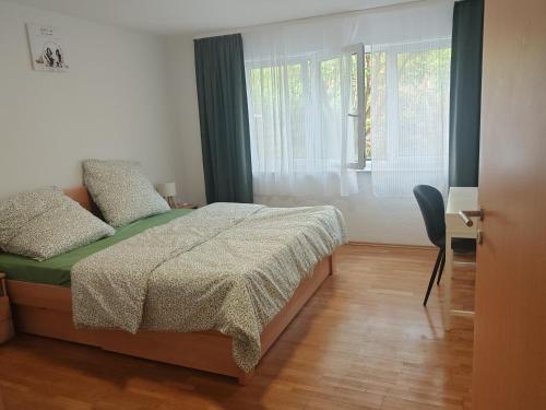 Schlafzimmer mit Doppelbett und großem Fenster im Garten Apartment
